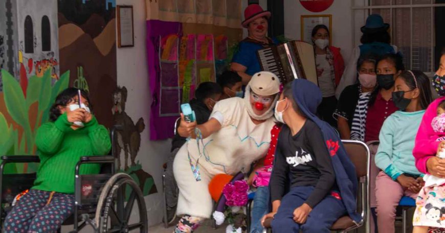 Darina takes a photo with an audience member at a clown show as others look on