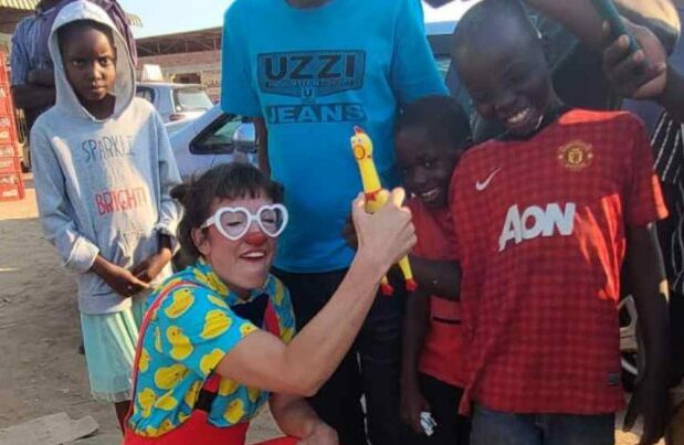 Clown with rubber chicken posing with kids