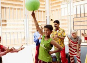 Kid balancing green ball