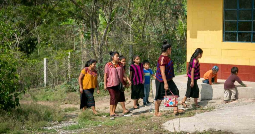 Indigenous people walking from the forest to building