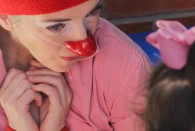 A clown gives a child a high five at a show.