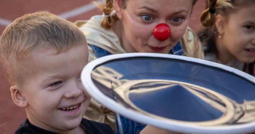 Clown and child balancing a plate