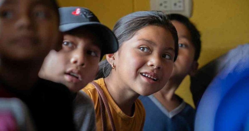 a young girl and boy look to the stage at a CWB clown show