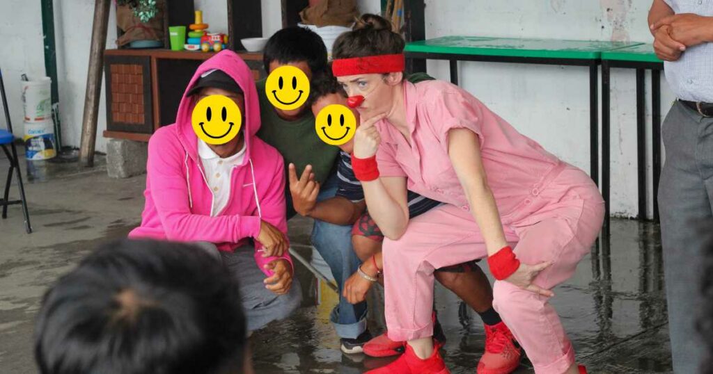 A clown poses with 3 young men at the clown show.