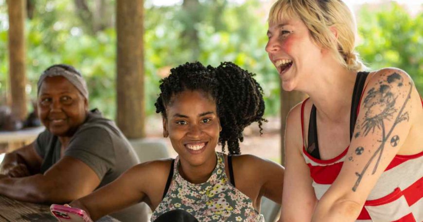 Women from Puerto Rico laugh with a clown in an outdoor setting.