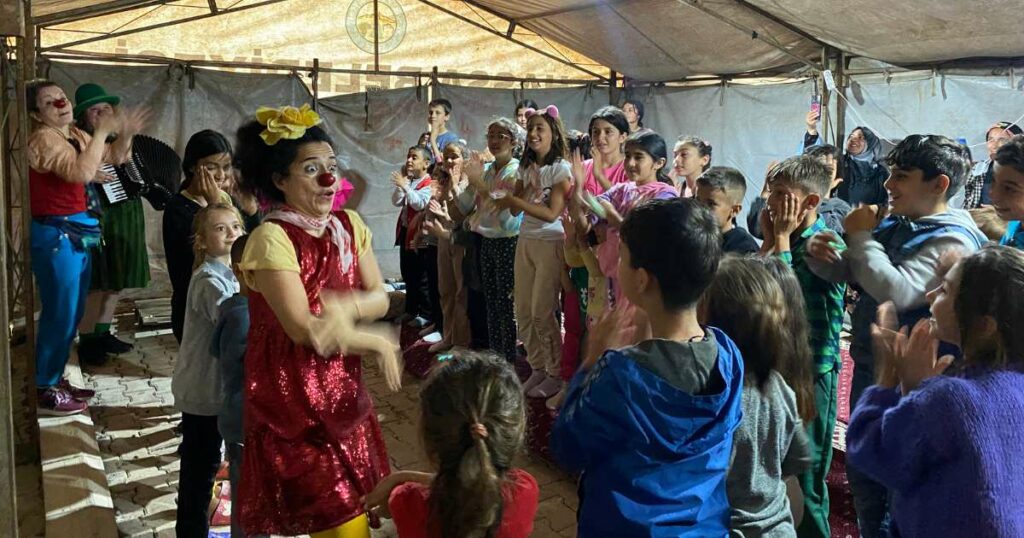 Women clowns perform in a tent in southern Turkey where people are still living in temporary housing.