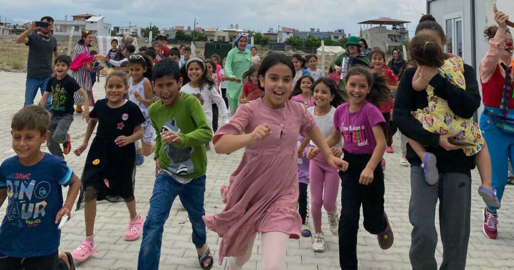 Happy kids running toward clowns in southern Turkey.