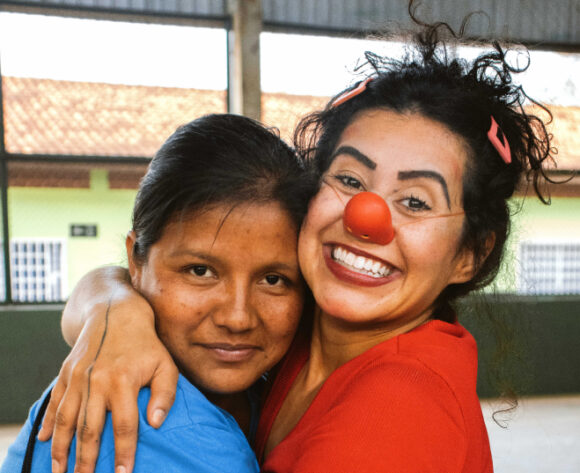 Clown embracing a child