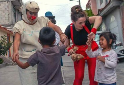 Clowns dancing with children