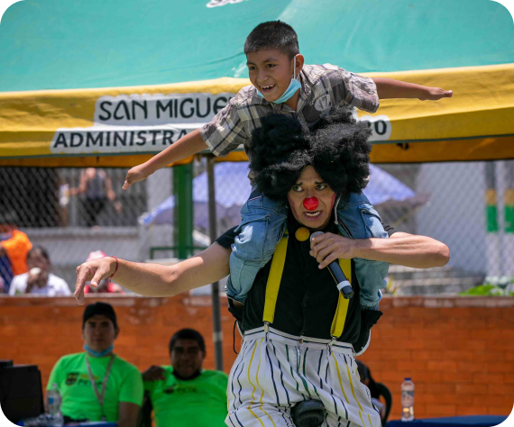 Clown giving kid a piggy back