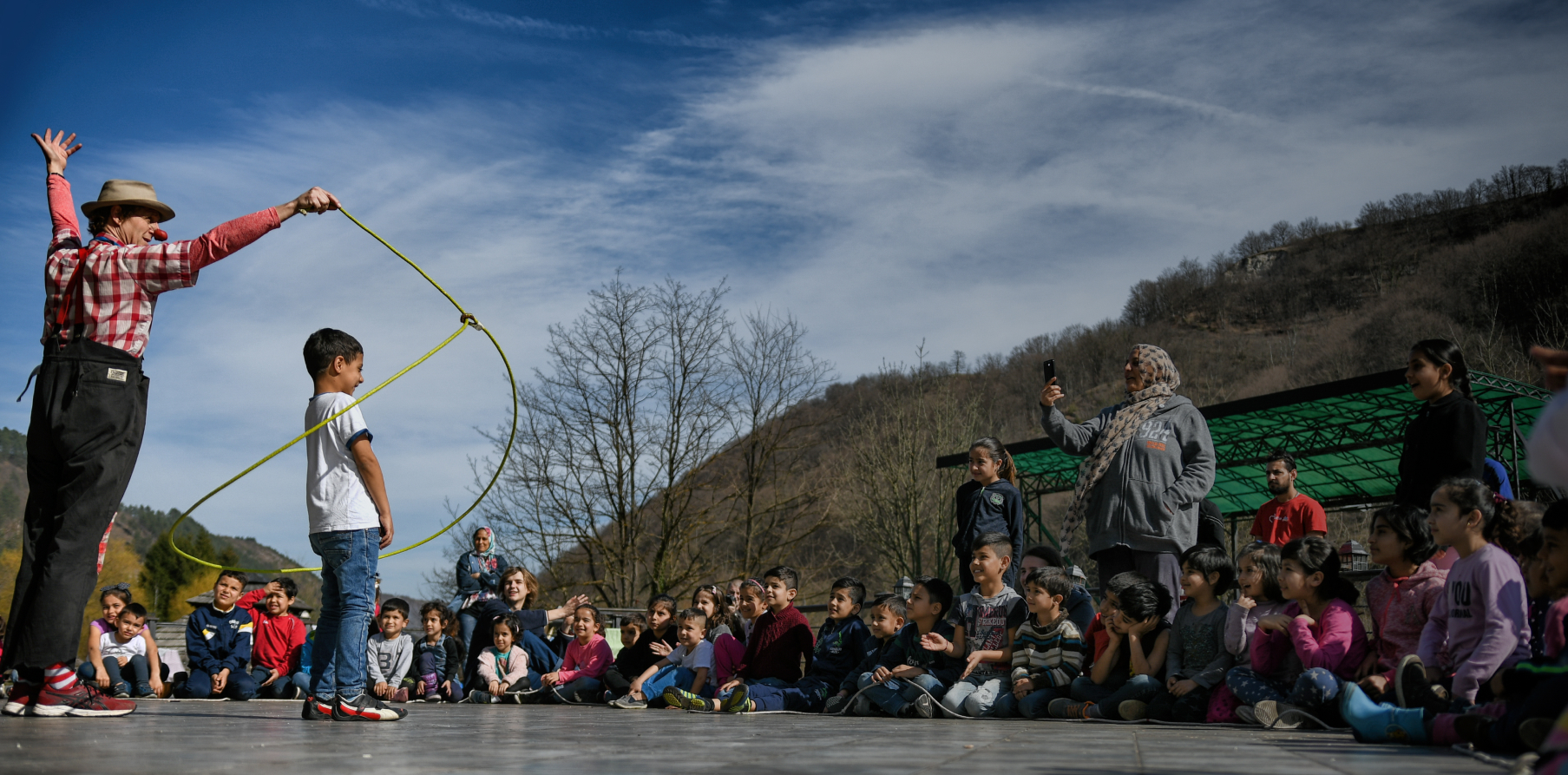 Clown with rope around kid