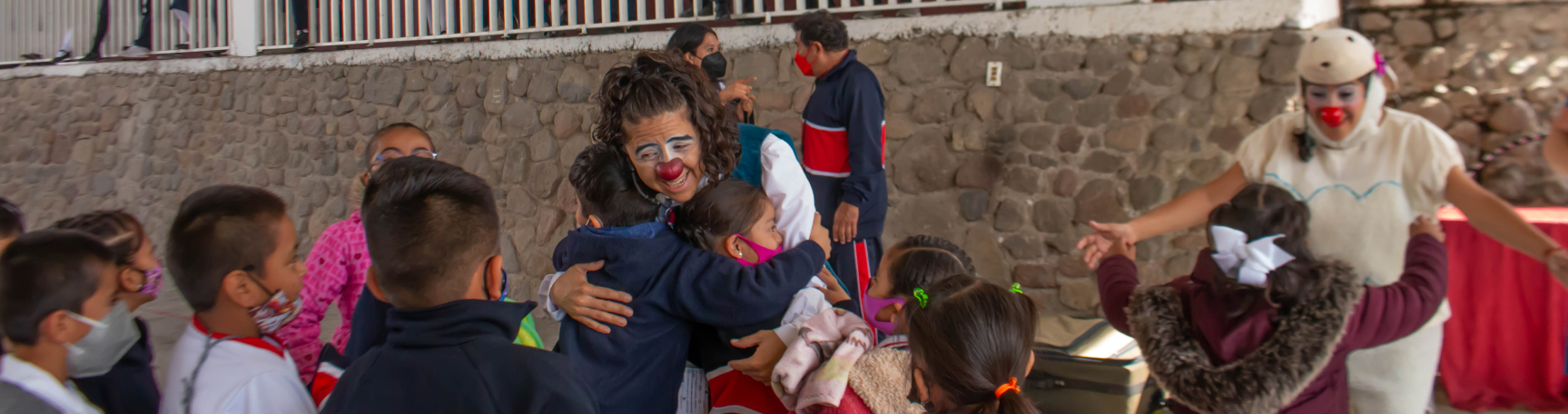 Clowns hugging kids