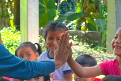 A child high-fives a clown during a tour in El Salvador